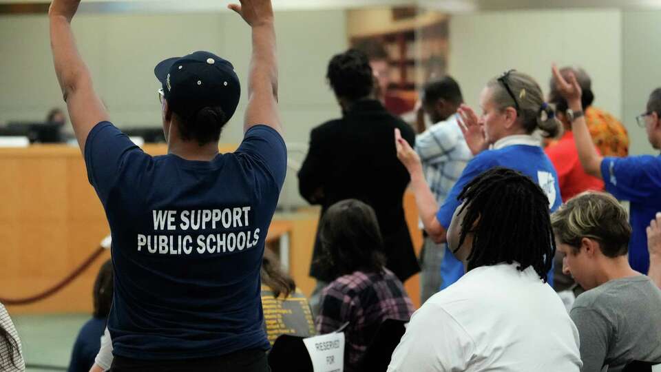 Community members stand up and support when Jackie Anderson, president of the Houston Federation of Teachers, is speaking during the public comment section of the first Board of Managers meeting since the HISD takeover Thursday, June 8, 2023, at Hattie Mae White Educational Support Center in Houston.