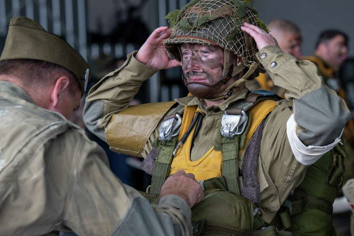 Michaela Serseloudi, of Latham, is inspected prior to jumping out of a C-47 airplane that flew on D-Day in 1944. The Airborne Demonstration Team were wearing authentic gear identical to paratroopers on D-Day during an exhibition at the third annual Wings & Wheels showcase to benefit the Prescott Foundation, which restores and maintains WWII aircraft and vehicles, at the Hangar at 743, on Saturday in Colonie.