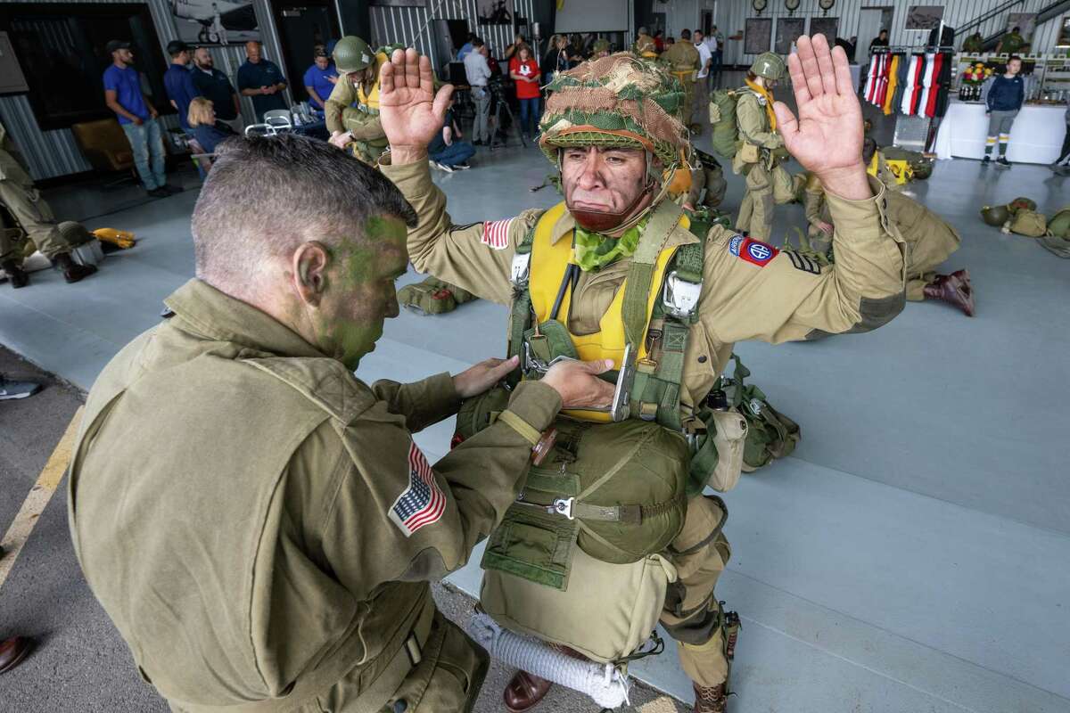 Vincent Mejia is inspected by Paul Narowski prior to jumping out of a C-47 airplane that flew on D-Day in 1944. The Airborne Demonstration Team were wearing authentic gear identical to paratroopers on D-Day during an exhibition at the third annual Wings & Wheels showcase to benefit the Prescott Foundation, which restores and maintains WWII aircraft and vehicles, at the Hangar at 743, on Saturday in Colonie.