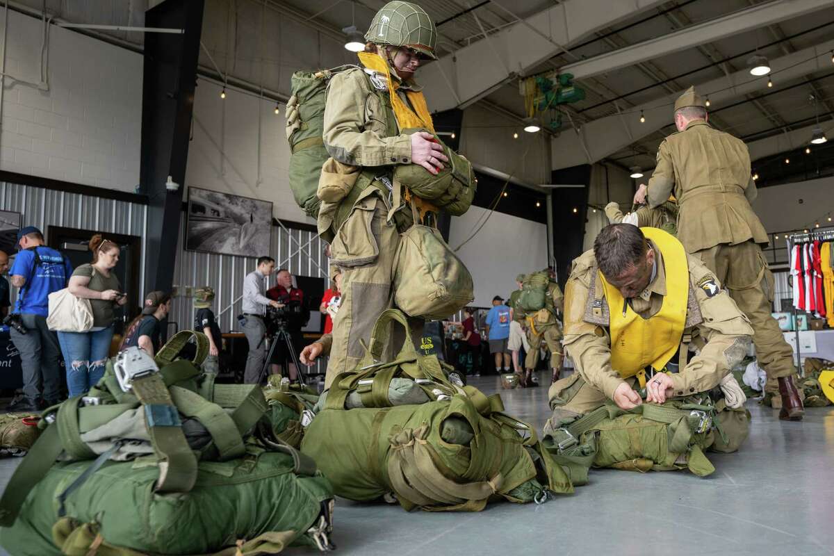 Members of the Airborne Demonstration Team, wearing authentic gear identical to paratroopers on D-Day in 1944, get prepared to jump out of a C-47 that flew on D-Day during an exhibition at the third annual Wings & Wheels showcase to benefit the Prescott Foundation, which restores and maintains WWII aircraft and vehicles, at the Hangar at 743, on Saturday in Colonie.