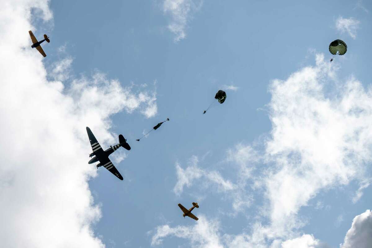 Members of the Airborne Demonstration Team, wearing authentic gear identical to paratroopers on D-Day in 1944, jump out of a C-47 that flew on D-Day during an exhibition at the third annual Wings & Wheels showcase to benefit the Prescott Foundation, which restores and maintains WWII aircraft and vehicles, at the Hangar at 743, on Saturday in Colonie.