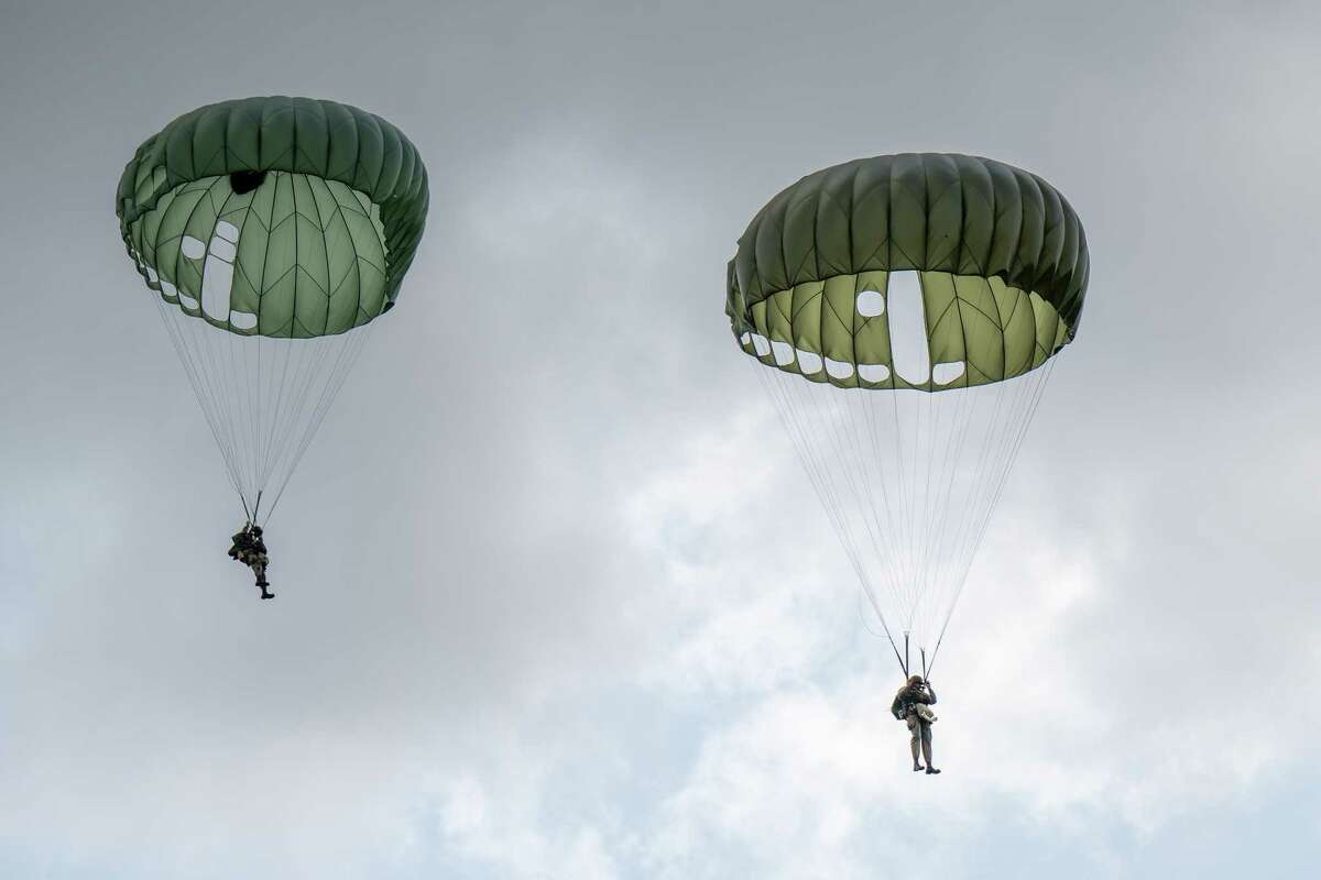 Members of the Airborne Demonstration Team, wearing authentic gear identical to paratroopers on D-Day in 1944, jump out of a C-47 that flew on D-Day during an exhibition at the third annual Wings & Wheels showcase to benefit the Prescott Foundation, which restores and maintains WWII aircraft and vehicles, at the Hangar at 743, on Saturday in Colonie.