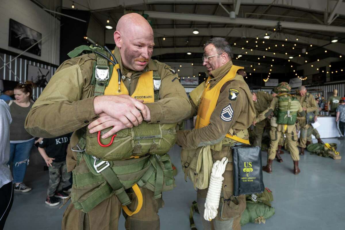 Steven Woodward is inspected by Doug Jessup prior to jumping out of a C-47 airplane that flew on D-Day in 1944. The Airborne Demonstration Team were wearing authentic gear identical to paratroopers on D-Day during an exhibition at the third annual Wings & Wheels showcase to benefit the Prescott Foundation, which restores and maintains WWII aircraft and vehicles, at the Hangar at 743, on Saturday in Colonie.