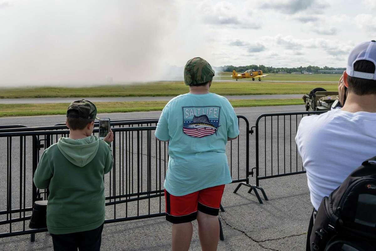 Spectators watch a plane take off during the third annual Wings & Wheels showcase to benefit the Prescott Foundation, which restores and maintains WWII aircraft and vehicles, at the Hangar at 743, on Saturday in Colonie.