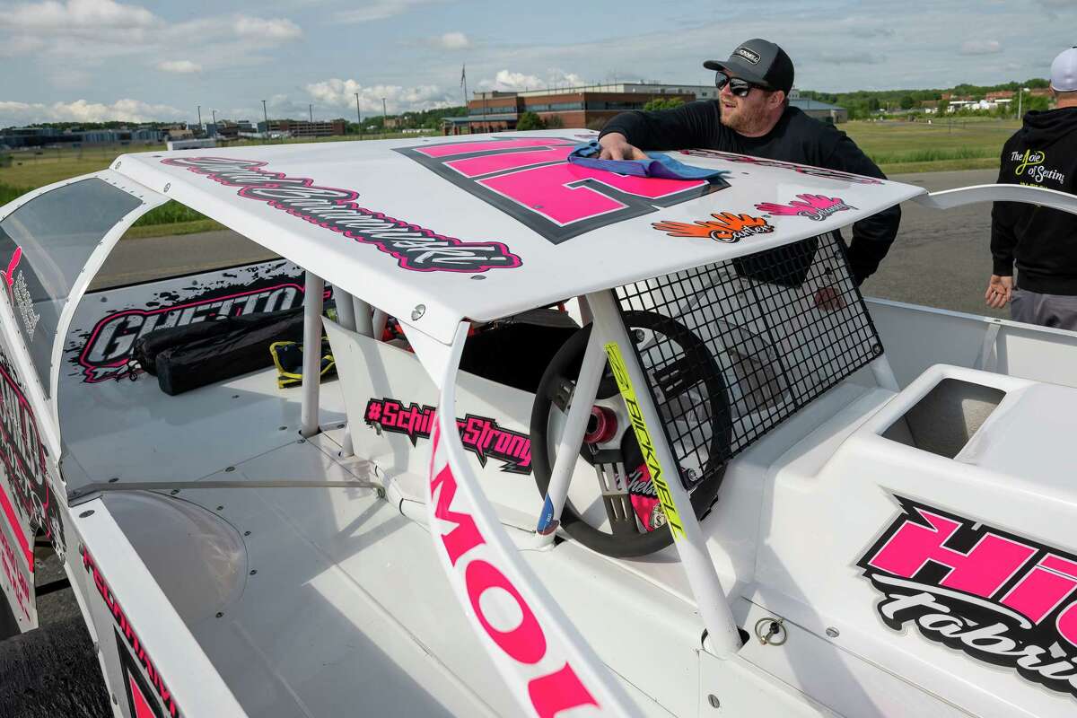 Evan Hoffman polishes his modified sportsman dirt car during the third annual Wings & Wheels showcase to benefit the Prescott Foundation, which restores and maintains WWII aircraft and vehicles, at the Hangar at 743, on Saturday in Colonie.