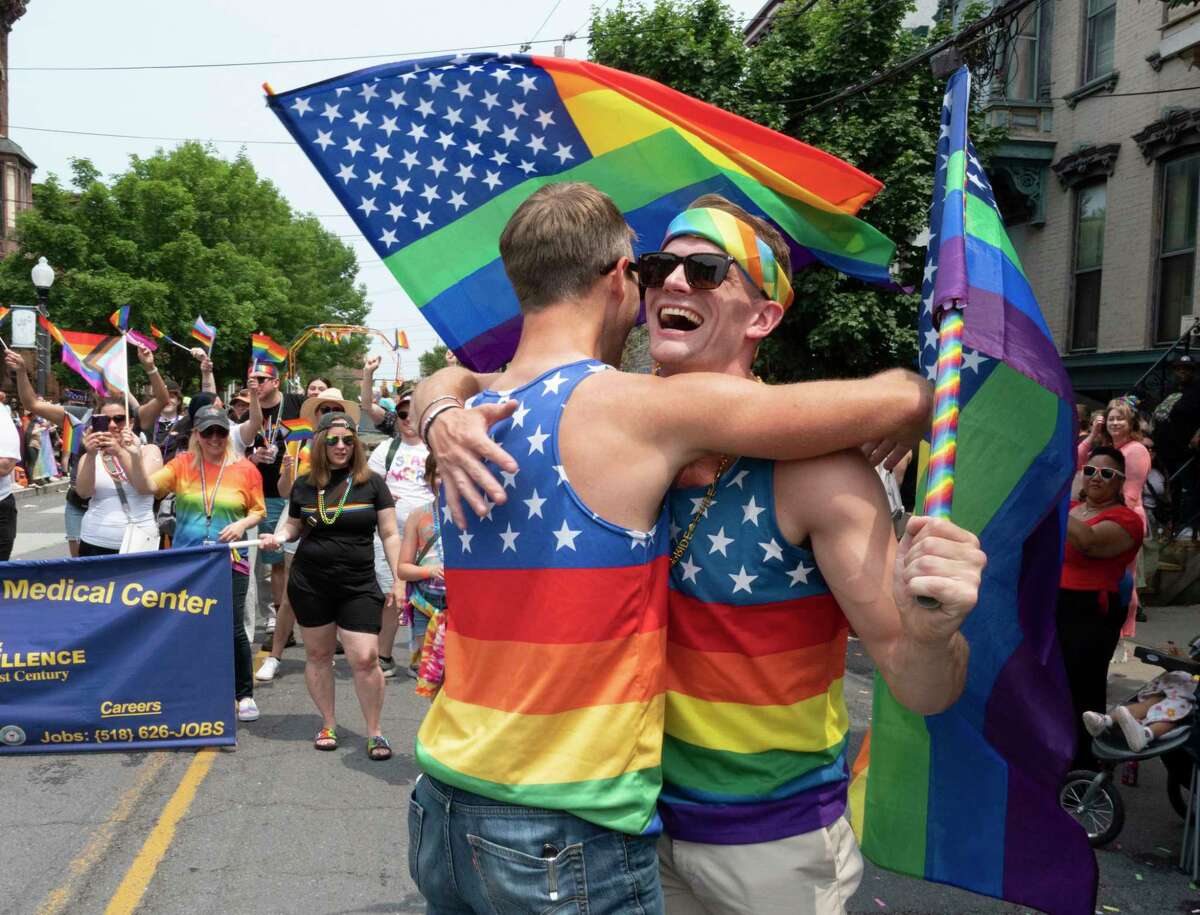 Alan Finder of Albany, left, gives Patrick DeVoe of Delmar a hug for wearing the same tank top as The Capital Pride Parade makes its way up Lark St. on Sunday, June 11, 2023, in Albany, N.Y. Music and festivities followed in Washington Park. (Lori Van Buren/Times Union)