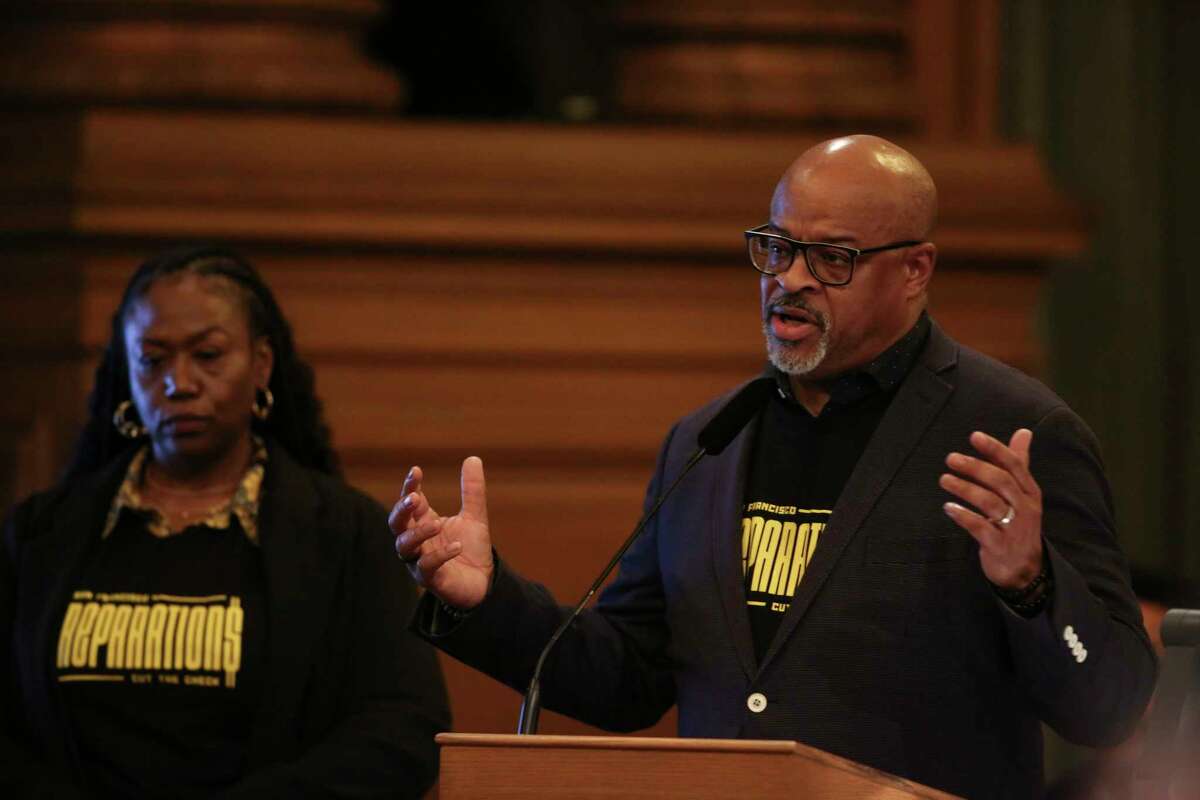 Eric McDonnell, right, chair of the African American Reparations Advisory Committee, speaks at the San Francisco Board of Supervisors’ public hearing about the city’s draft reparations plan at City Hall in San Francisco on March 14. The committee submitted its final report over the summer, ending a two-year process of studying how the legacy of chattel slavery in the U.S. has impacted generations of Black San Franciscans. For committee members like McDonnell, the reparations journey in the state is far from over and should remain an important part of the 2024 election cycle. 