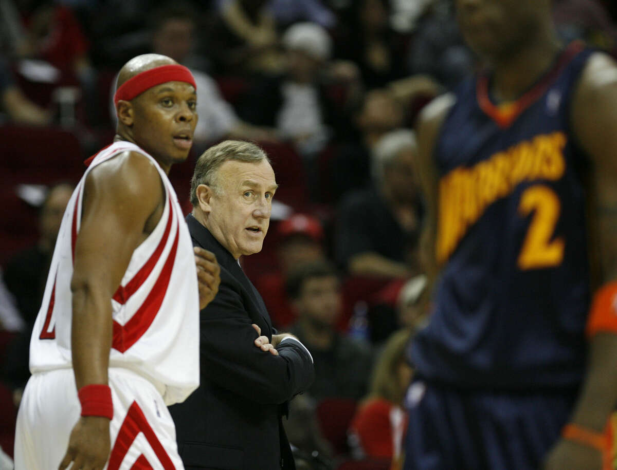 Houston Rockets head coach Rick Adelman (center) looks on against Golden State Warriors' Mickael Pietrus (right) as Rockets' Bonzi Wells passes during the second quarter of an NBA game at the Toyota Center, Monday, Dec. 31, 2007, in Houston.