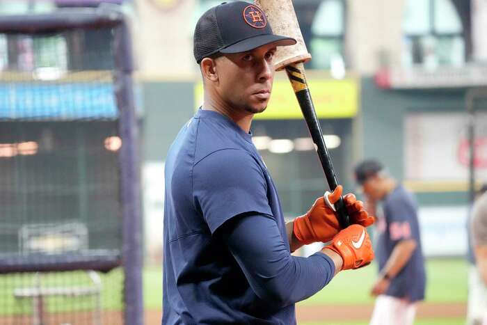 Houston Astros' Chas McCormick, left, and Mauricio Dubon, right, try to get  their gloves on a ball hit by Boston Red Sox's Alex Verdugo in the fourth  inning of a baseball game