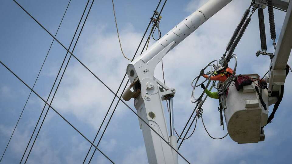 Men work on transmission lines Wednesday, June 21, 2023 in the Montrose neighborhood in Houston.