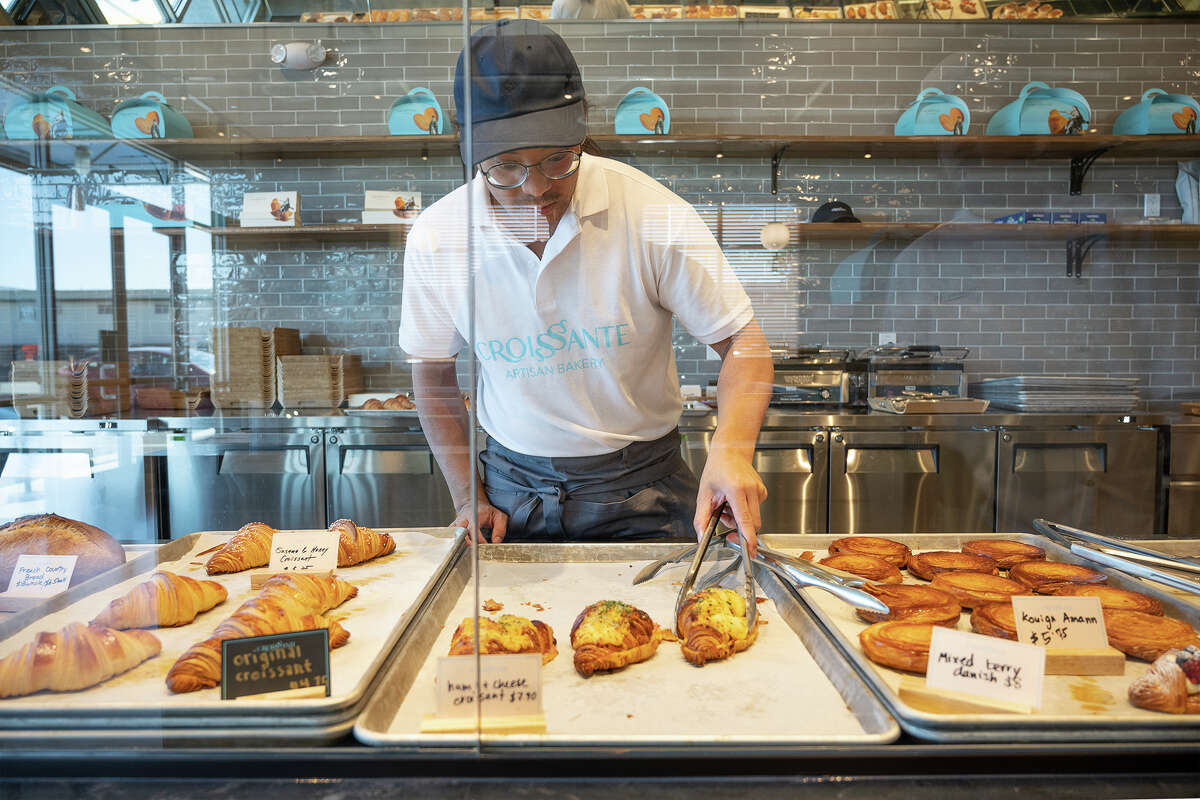 Hieu Tran grabs a ham and cheese croissant for a customer at Croissante in Santa Clara Calif., June 20, 2023