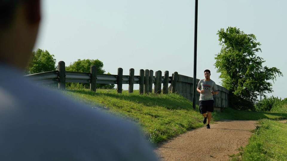 A runner exrcises on a trail right on an active dumping site on North Main Street next to Galena Park Sports Complex on Monday, June 20, 2023 in Galena Park.