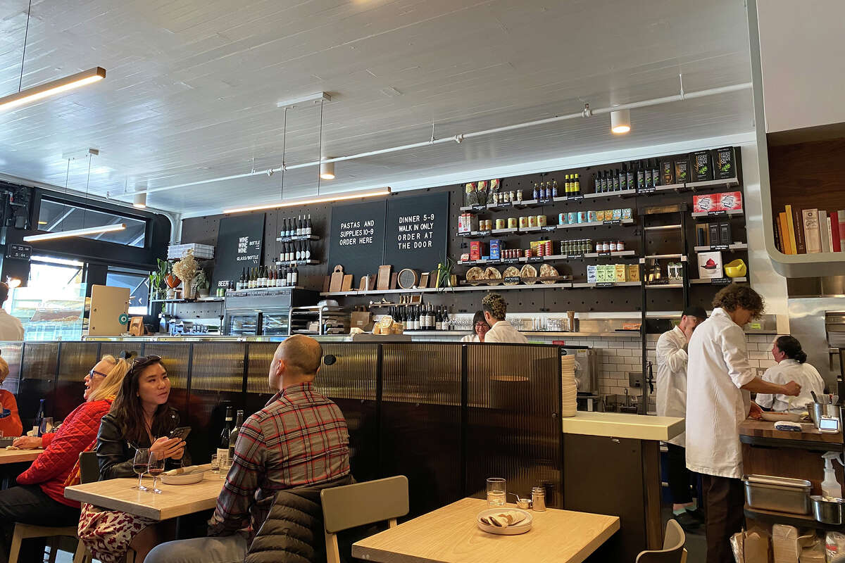 An interior shot of Pasta Supply Co. shows the deli counter and the dining area.