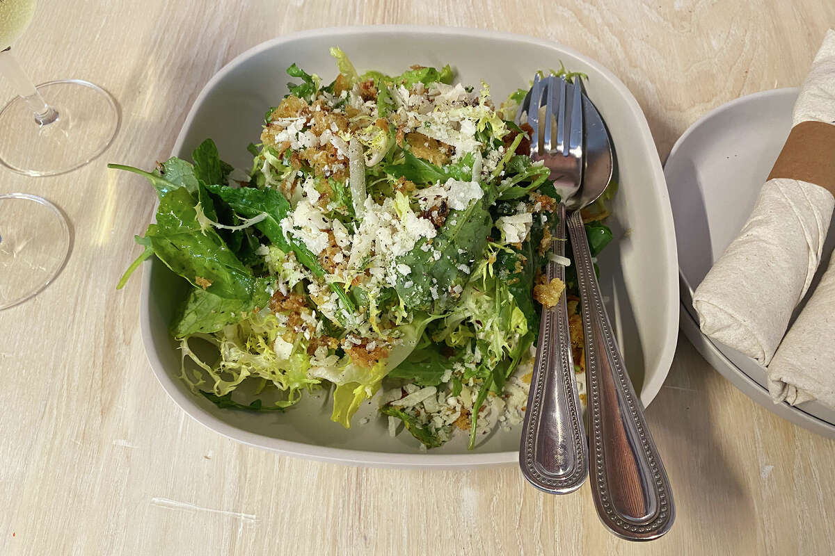 The house greens salad with parmesan and fried bread crumbs in a lemon-based dressing.