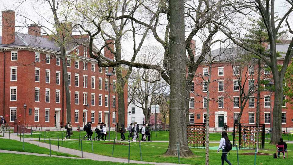 FILE - Students walk through Harvard Yard, April 27, 2022, on the campus of Harvard University in Cambridge, Mass.