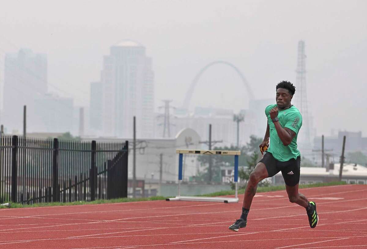 Smoke from the Canadian wildfires obscures the St. Louis skyline as Keith Major runs sprints on the track at St. Louis University on Wednesday, June 28, 2023. Major, a police officer in the city of St. Louis, is training for the World Police and Fire Games that is being held in Winnipeg, He said he was concerned about the air quality and compared training in the smoky air to training at high altitudes.