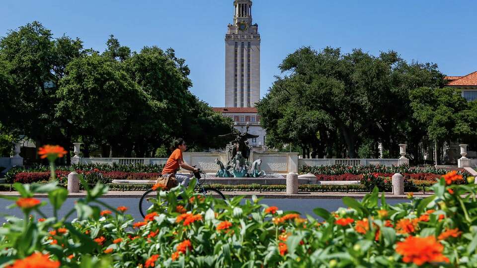 A student rides a bike towards the University of Texas at Austin campus on Wednesday, June 28, 2023 in Austin