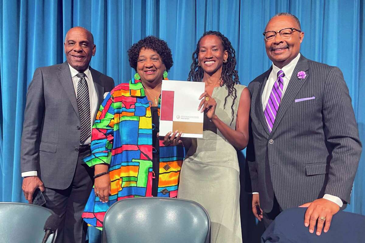 State Sen. Steven Bradford (left), Secretary of State Shirley Weber, task force member Lisa Holder and Assembly Member Reggie Jones-Sawyer hold up the California Reparations Task Force’s final report during a hearing in Sacramento on June 29.