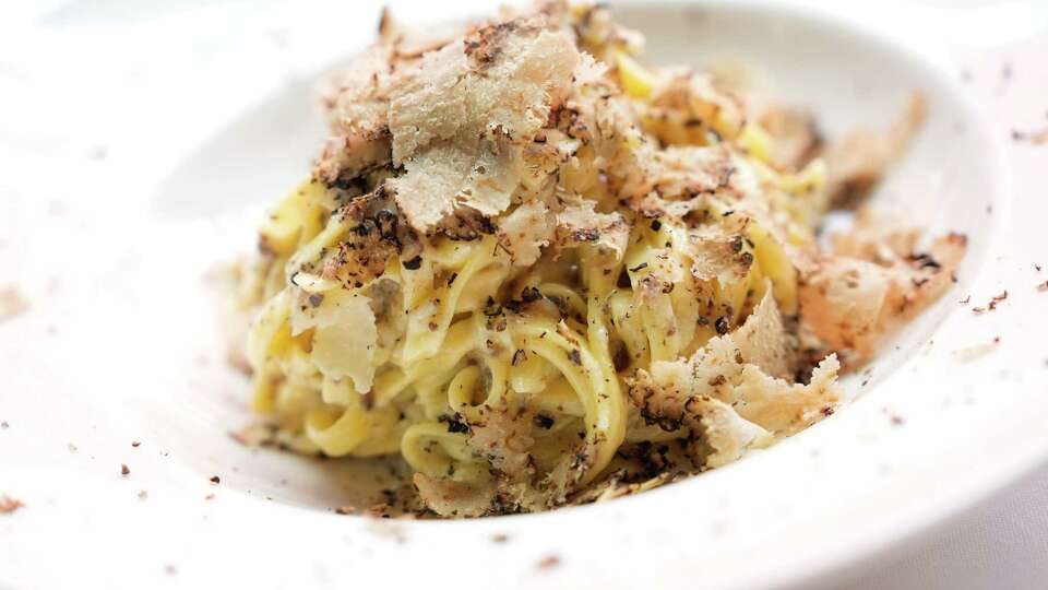 Bari Chef Renato De Pirro shaves truffle over truffle pasta that was tossed in a cheese wheel on Thursday, June 29, 2023 at River Oaks District in Houston.