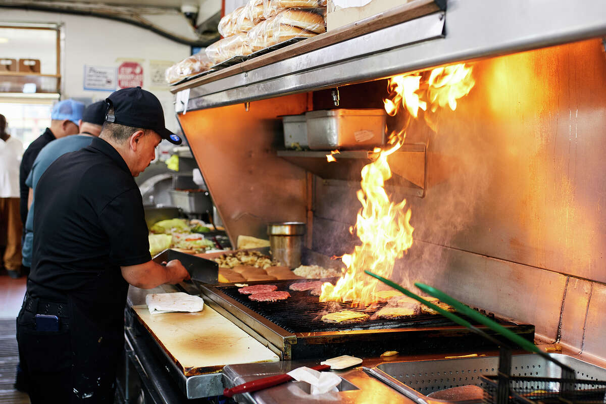 Employees make burgers at Lucky Boy in Pasadena, Calif., on Thursday.