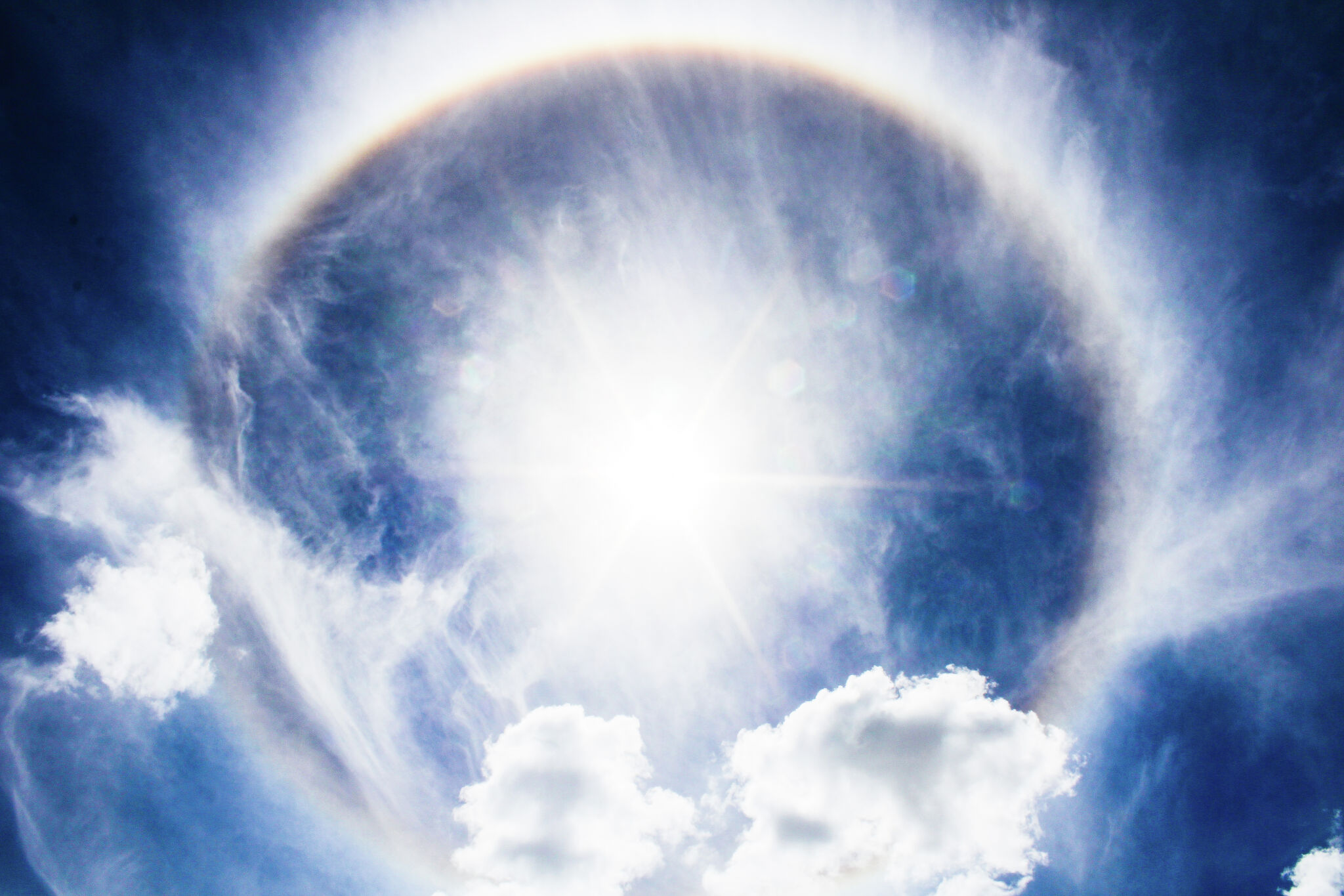 Sun Halo or a rainbow-colored ring around the sun. Sunny sky with sun halo.  Optical phenomenon produced by light. Cirrus or cirrostratus clouds in the  troposphere with light refraction and reflection. 9370703