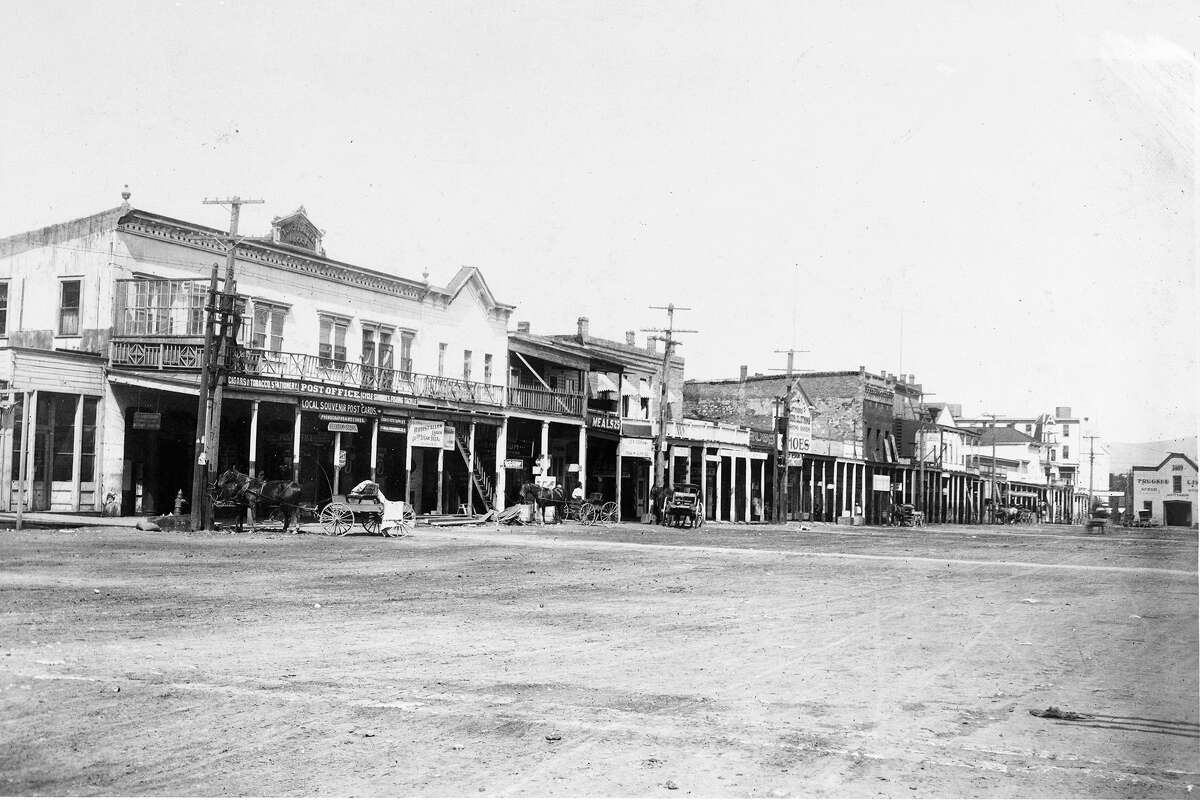 Photograph of a wide dirt street in Truckee showing a line of commercial buildings, circa 1880.