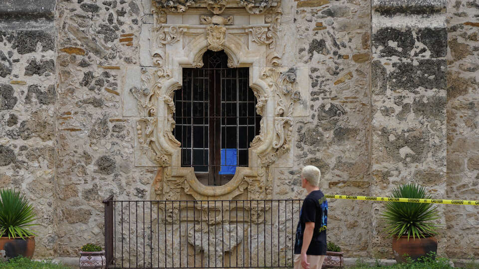 A broken pane of glass from the San José Missions' Rose Window is covered in blue painters tape Friday morning. Officials said individuals attempting to gain entry to the UNESCO World Heritage Site damaged the window.