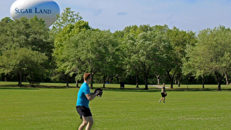 A pair of teenagers playing catch at Oyster Creek Park.