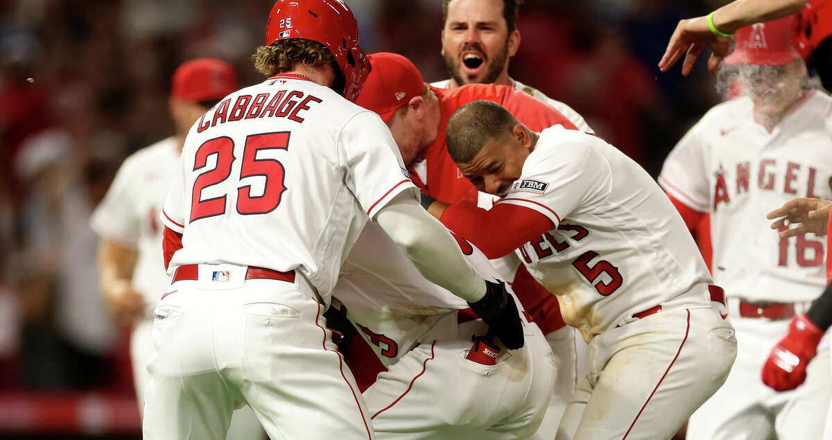 Houston Astros' Jose Altuve (R) walks with Los Angeles Angels Mike