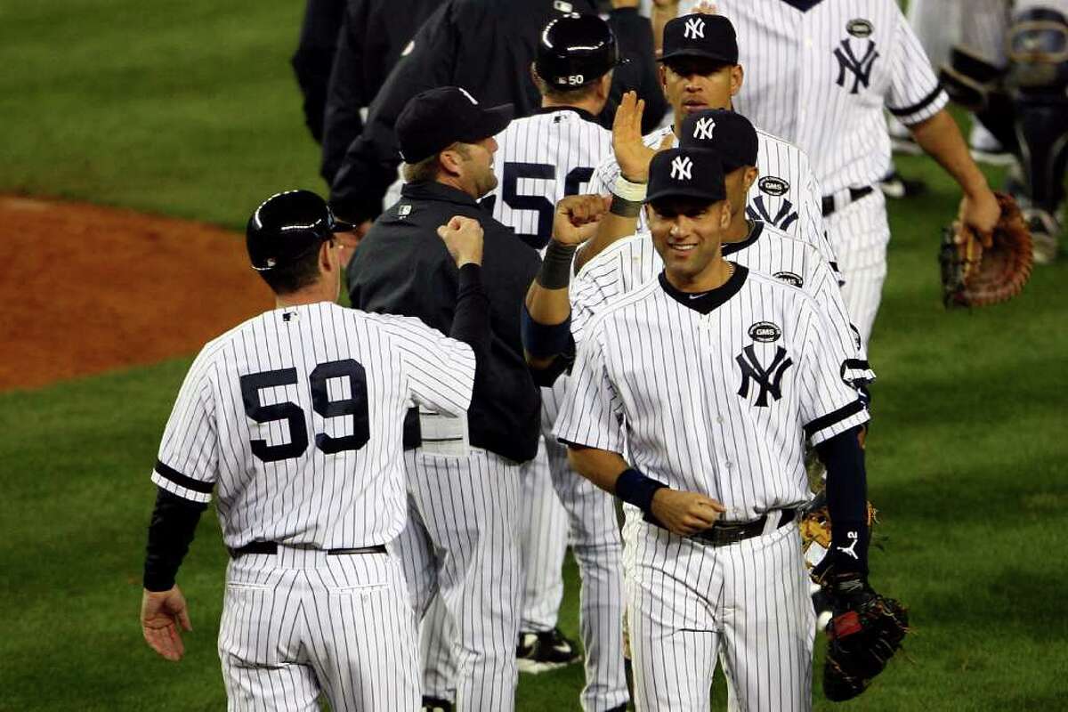 NEW YORK - OCTOBER 20: Derek Jeter #2 of the New York Yankees celebrates with his teammates after the Yankees won 7-2 against the Texas Rangers in Game Five of the ALCS during the 2010 MLB Playoffs at Yankee Stadium on October 20, 2010 in the Bronx borough of New York City. (Photo by Andrew Burton/Getty Images) *** Local Caption *** Derek Jeter