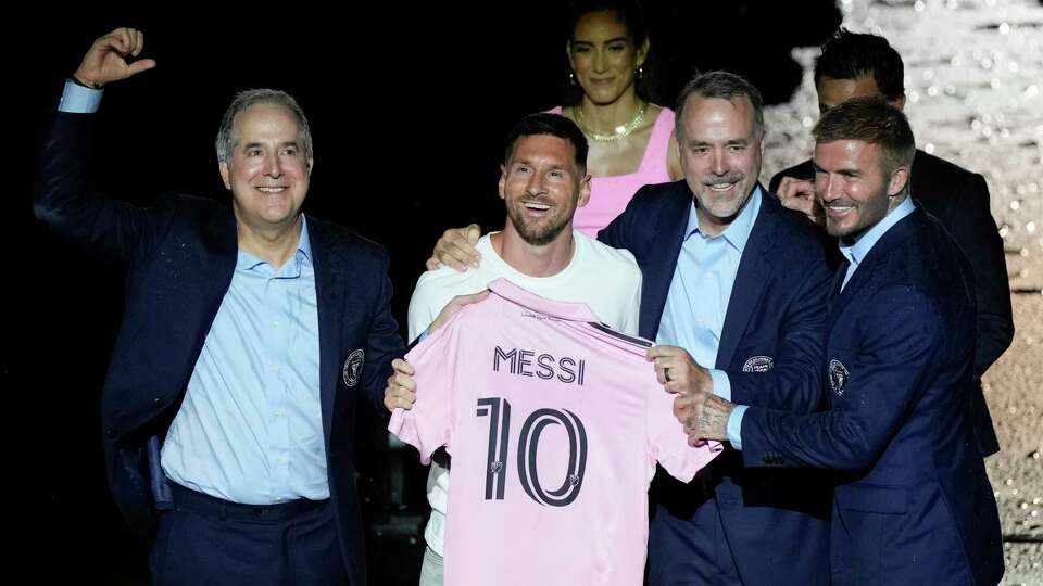 lnInternational superstar Lionel Messi, center left, holds his new Inter Miami team jersey as he poses with team co-owners Jorge Mas, left, Jose Mas, second right, and David Beckham, right, at an event to present him to fans one day after his signing, Sunday, July 16, 2023, in Fort Lauderdale, Fla. (AP Photo/Rebecca Blackwell)