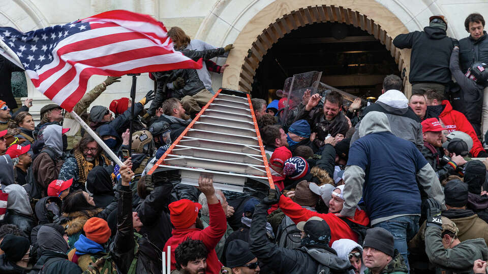 Insurrectionists clashing with police use a ladder to try to force entry into the Capitol on Jan. 6, 2021, in Washington, D.C. Rioters broke windows and breached the Capitol in an attempt to overthrow the results of the 2020 election. (Lev Radin/Pacific Press via ZUMA Wire/TNS)