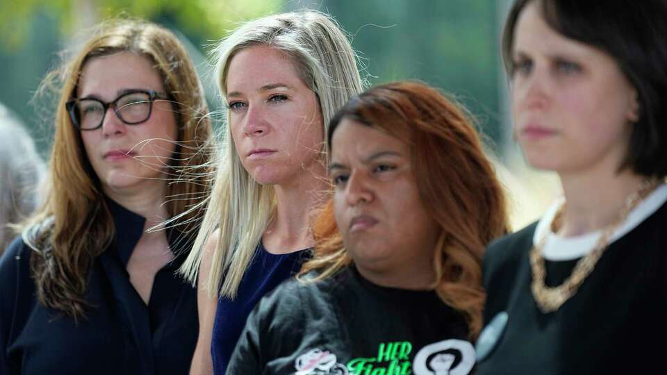 Amanda Zurawski, who developed sepsis and nearly died after being refused an abortion when her water broke at 18 weeks, second from left, and Samantha Casiano, who was forced to carry a nonviable pregnancy to term and give birth to a baby who died four hours after birth, second from right, stand with their attorney, stand with other plaintiffs and their attorneys outside the Travis County Courthouse, Wednesday, July 19, 2023, in Austin, Texas.