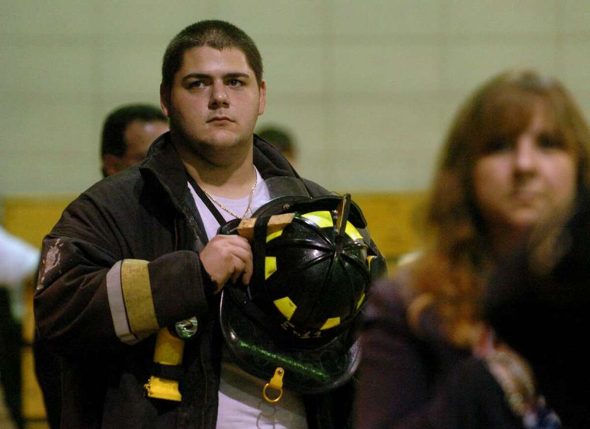A 9-11 memorial service was held at Emmett O'Brien Technical School in Ansonia, Conn. on Friday Sept. 11, 2009. Here, Derby and Ansonia volunteer fireman Franco Pelaccia holds his helmet to his chest during the Star Spangled Banner.