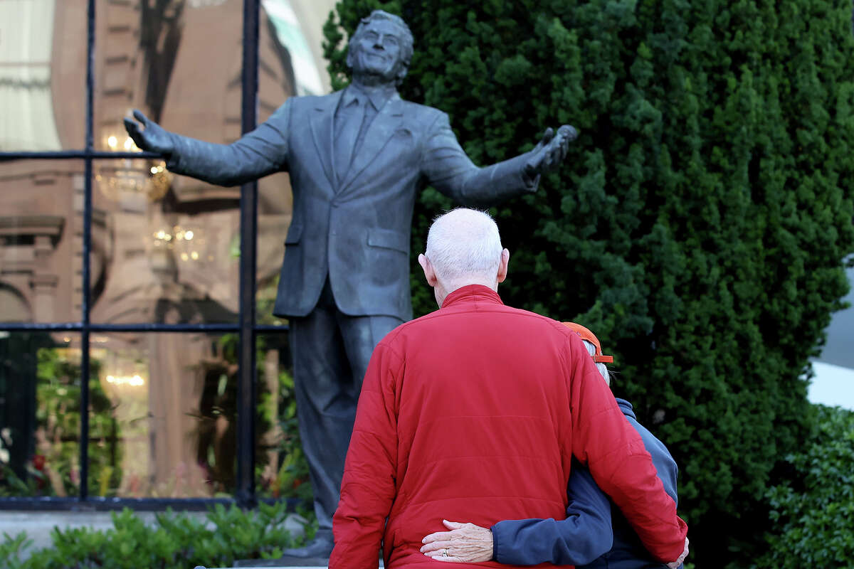 Visitors look at a statue of Tony Bennett at the Fairmont Hotel on July 21, 2023, in San Francisco.