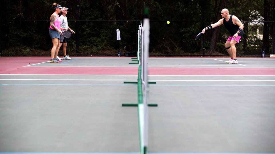 Pickleball players warm up during the DUPR Platinum Ticket Local Waterfall Tournament at Shadowbend Park, Saturday, July 22, 2023, in The Woodlands. Winners of the tournament advanced to play in the national tournament in Rockwall, Texas, in October.