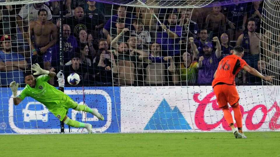 Orlando City goalkeeper Pedro Gallese, left, blocks a penalty kick by Houston Dynamo midfielder Hector Herrera (16) which was the deciding factor in a shootout to break a 1-1 tie during the second half of a Leagues Cup soccer match, Friday, July 21, 2023, in Orlando, Fla. (AP Photo/John Raoux)