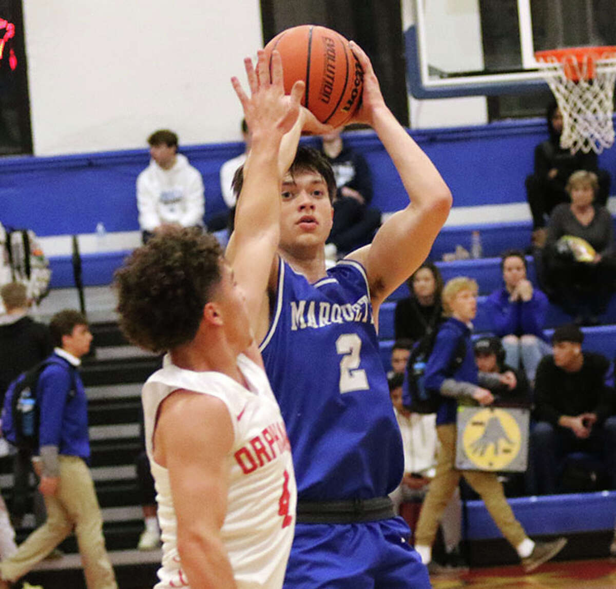 Marquette Catholic's Braden Kline (right) shoots a 3-pointer over a Centralia defender in a game last November at the Roxana Hoopsgiving Classic.