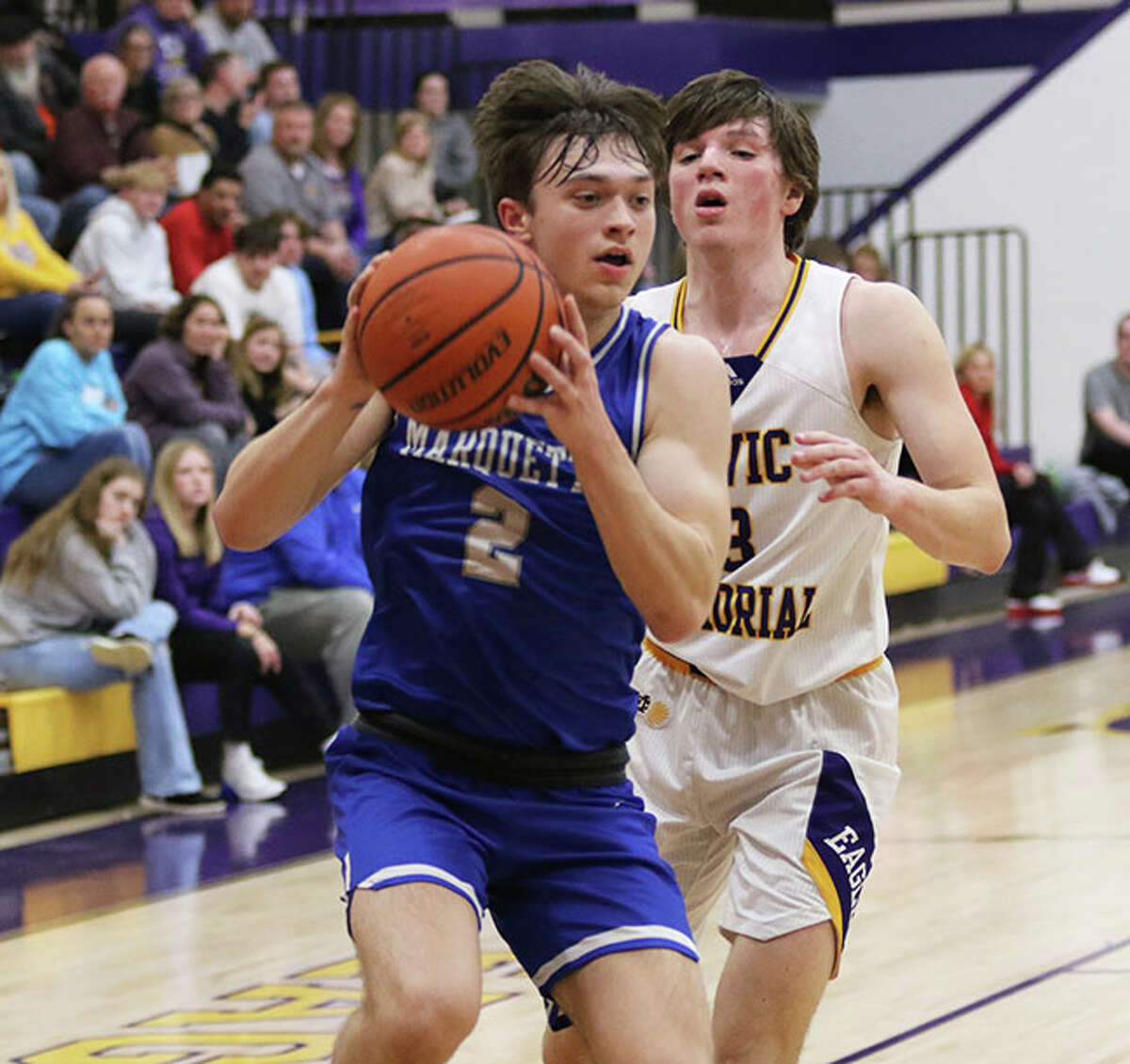 Marquette Catholic's Braden Kline (2) goes to the basket against CM's Manny Silva in a Feb. 14 game at Bethalto.