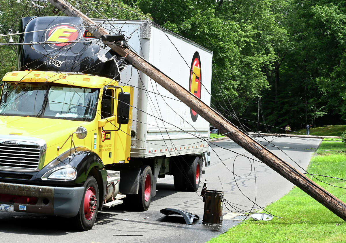 The scene after this tractor trailer truck took down two poles on Monday, July 24, 2023, in Vernon. The driver was uninjured but couldn't leave the cab until the power was cut. The accident happened on Valerie Drive in a quiet residential neighborhood around 12:30 p.m. The truck became tangled in low-hanging power lines that wrapped around the top of the trailer. The truck took out two utility poles before coming to a stop. Fire officials asked the power company to shut down the power in the area so the driver could get out safely.