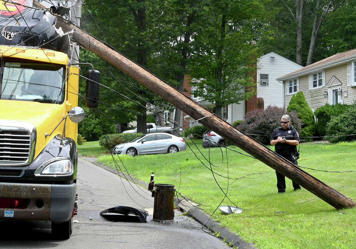 The scene after this tractor trailer truck took down two poles on Monday, July 24, 2023, in Vernon. The driver was uninjured but couldn't leave the cab until the power was cut. The accident happened on Valerie Drive in a quiet residential neighborhood around 12:30 p.m. The truck became tangled in low-hanging power lines that wrapped around the top of the trailer. The truck took out two utility poles before coming to a stop. Fire officials asked the power company to shut down the power in the area so the driver could get out safely.