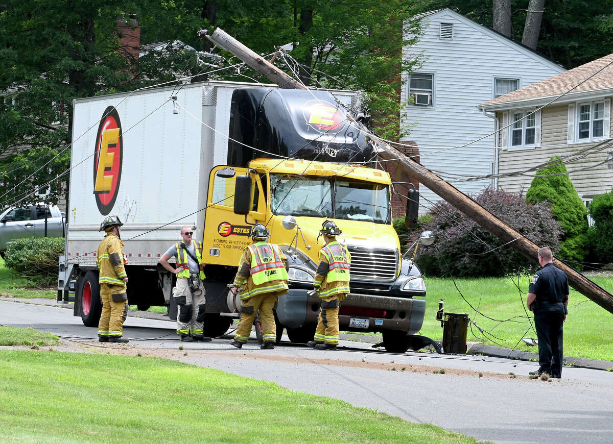 The scene after this tractor trailer truck took down two poles on Monday, July 24, 2023, in Vernon. The driver was uninjured but couldn't leave the cab until the power was cut. The accident happened on Valerie Drive in a quiet residential neighborhood around 12:30 p.m. The truck became tangled in low-hanging power lines that wrapped around the top of the trailer. The truck took out two utility poles before coming to a stop. Fire officials asked the power company to shut down the power in the area so the driver could get out safely.