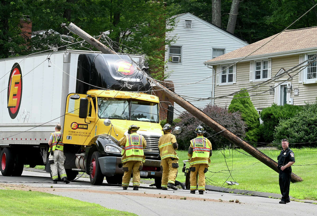 The scene after this tractor trailer truck took down two poles on Monday, July 24, 2023, in Vernon. The driver was uninjured but couldn't leave the cab until the power was cut. The accident happened on Valerie Drive in a quiet residential neighborhood around 12:30 p.m. The truck became tangled in low-hanging power lines that wrapped around the top of the trailer. The truck took out two utility poles before coming to a stop. Fire officials asked the power company to shut down the power in the area so the driver could get out safely.