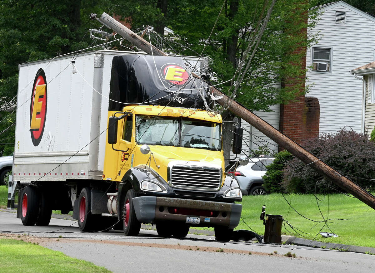 The scene after this tractor trailer truck took down two poles on Monday, July 24, 2023, in Vernon. The driver was uninjured but couldn't leave the cab until the power was cut. The accident happened on Valerie Drive in a quiet residential neighborhood around 12:30 p.m. The truck became tangled in low-hanging power lines that wrapped around the top of the trailer. The truck took out two utility poles before coming to a stop. Fire officials asked the power company to shut down the power in the area so the driver could get out safely.