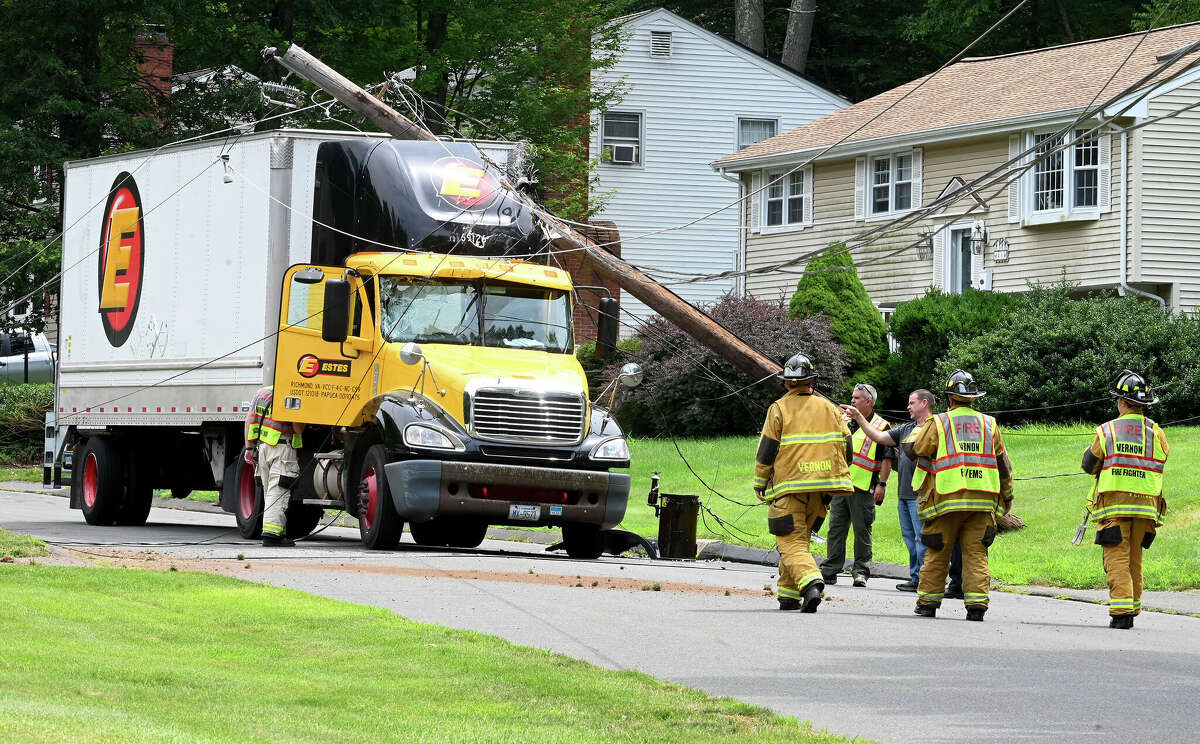 The scene after this tractor trailer truck took down two poles on Monday, July 24, 2023, in Vernon. The driver was uninjured but couldn't leave the cab until the power was cut. The accident happened on Valerie Drive in a quiet residential neighborhood around 12:30 p.m. The truck became tangled in low-hanging power lines that wrapped around the top of the trailer. The truck took out two utility poles before coming to a stop. Fire officials asked the power company to shut down the power in the area so the driver could get out safely.