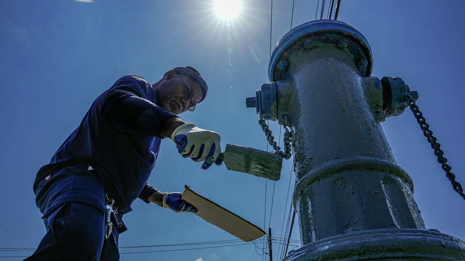 City of Bellaire Public Works worker Othal Choochoo works painting fire hydrants during a heat wave on Wednesday, June 28, 2023 in Houston.