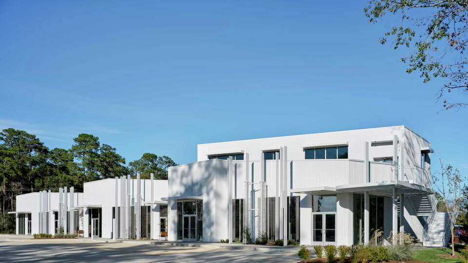 Plants, horizontal structures such as pergolas and vertical architectural fins, plus a corrugated concrete exterior all help keep this commercial building in Conroe cooler.