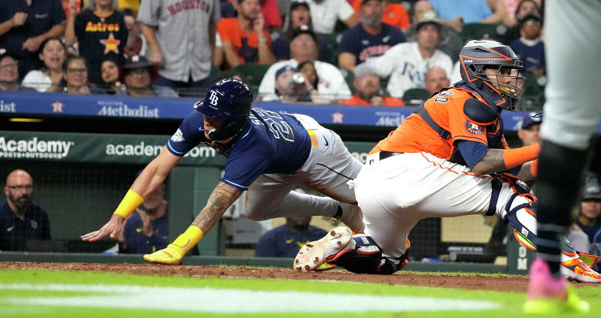 Houston Astros' Corey Julks, left, slides to score behind Atlanta