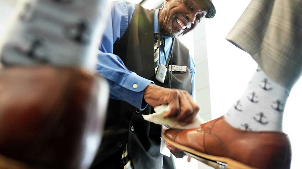 Rudolph Smith, 88, shines the shoes of his client, Carey Treadwell in the Hilton Houston North on Wednesday, Aug. 2, 2023 in Houston. Smith, whose always been an entrepreneur, has been shining shoes for over 20 years.