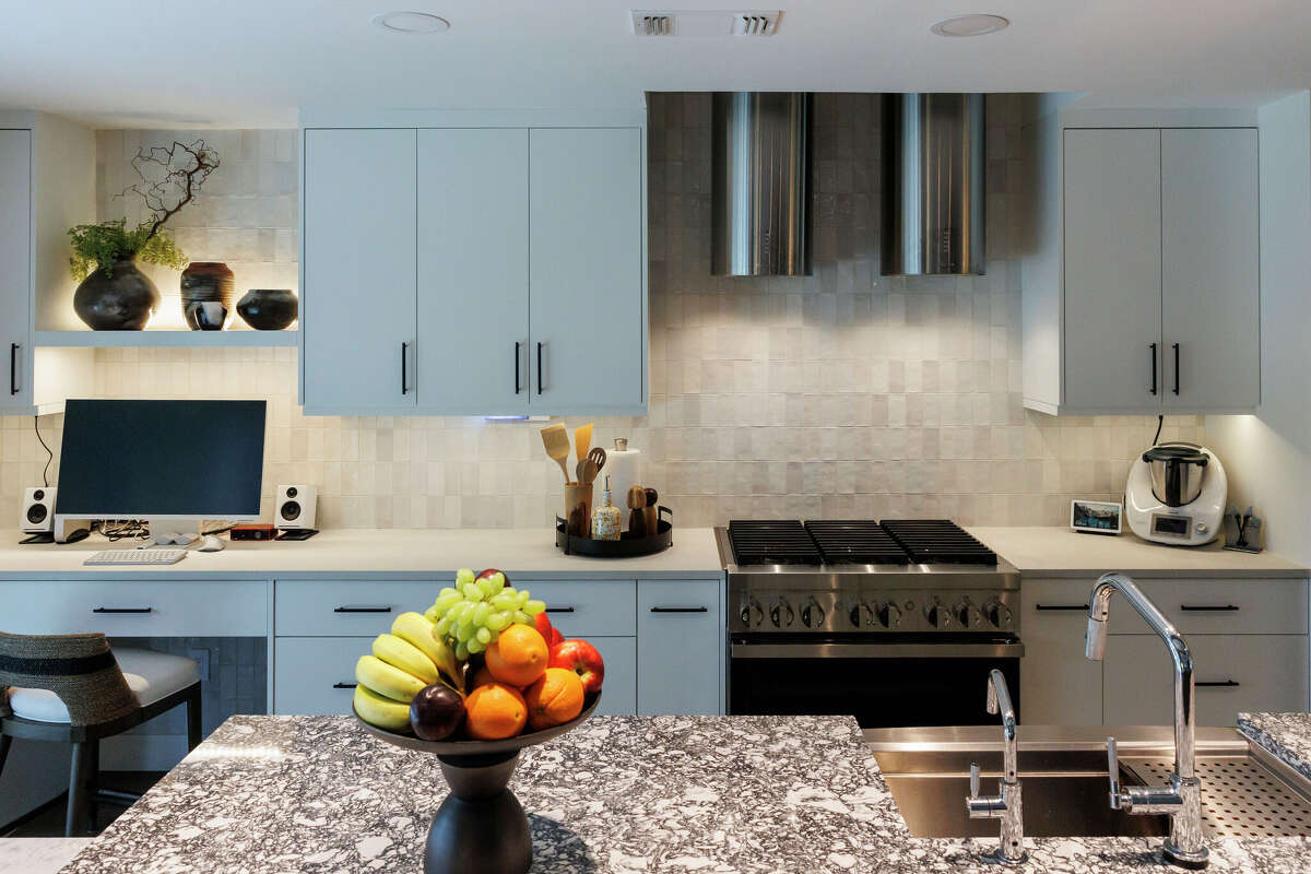 At the kitchen’s center is a large island topped with quartz in a swirled, black-and-white pattern.